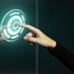 Hand pressing a glowing holographic power button, symbolizing technology upgrades and digital transformation for businesses.