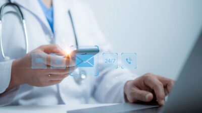 professional using phone and laptop with digital icons showing 24/7 communication and support, representing CMIT Solutions Atlanta IT services for email management